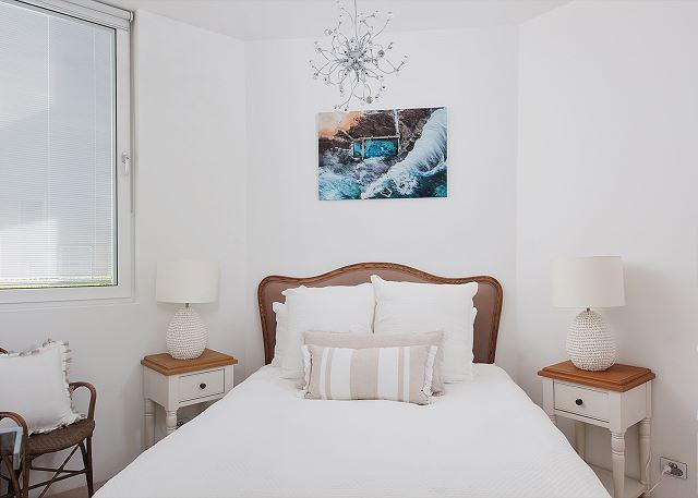 Bedroom with made bed and bedside lamps