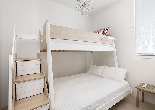 Timber bunk room with a double bed below and a single on top