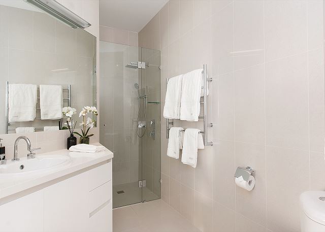 Second bathroom with glass shower and heated towel rails